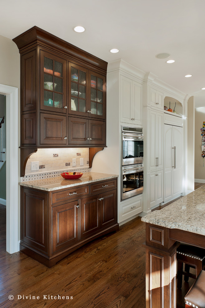 Elegant galley medium tone wood floor eat-in kitchen photo in Boston with a farmhouse sink, beaded inset cabinets, brown cabinets, granite countertops, multicolored backsplash, stainless steel appliances and an island