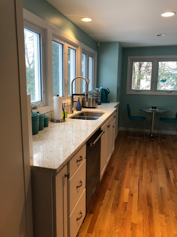 Idéer för att renovera ett vintage kök, med en dubbel diskho, bänkskiva i återvunnet glas, grönt stänkskydd, stänkskydd i glaskakel, rostfria vitvaror och en halv köksö