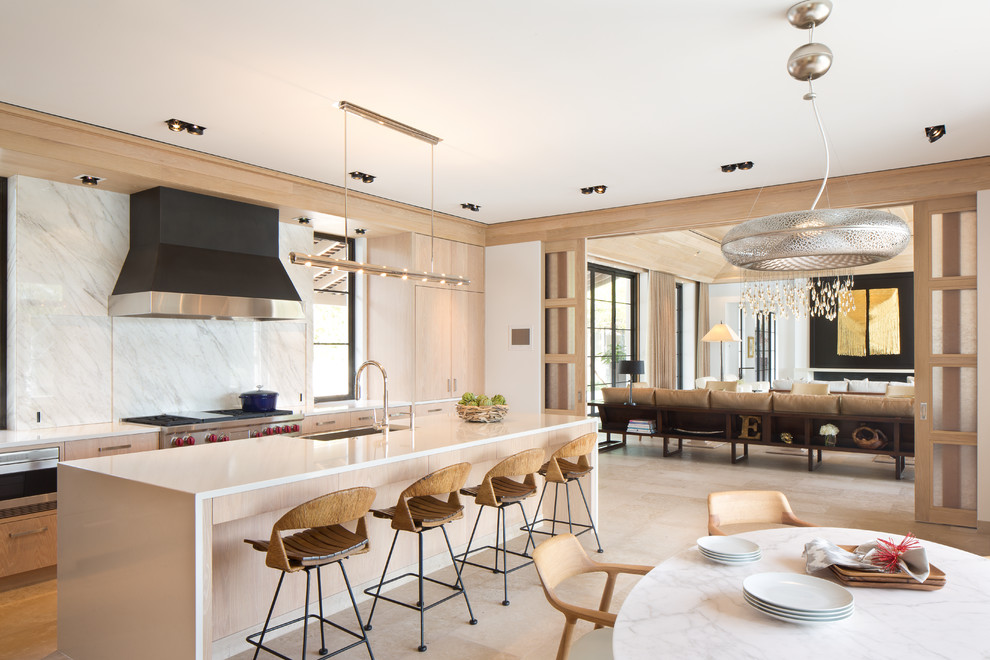 Immagine di una cucina costiera con ante lisce, ante in legno chiaro, paraspruzzi bianco, paraspruzzi in marmo, elettrodomestici in acciaio inossidabile, pavimento beige e top bianco