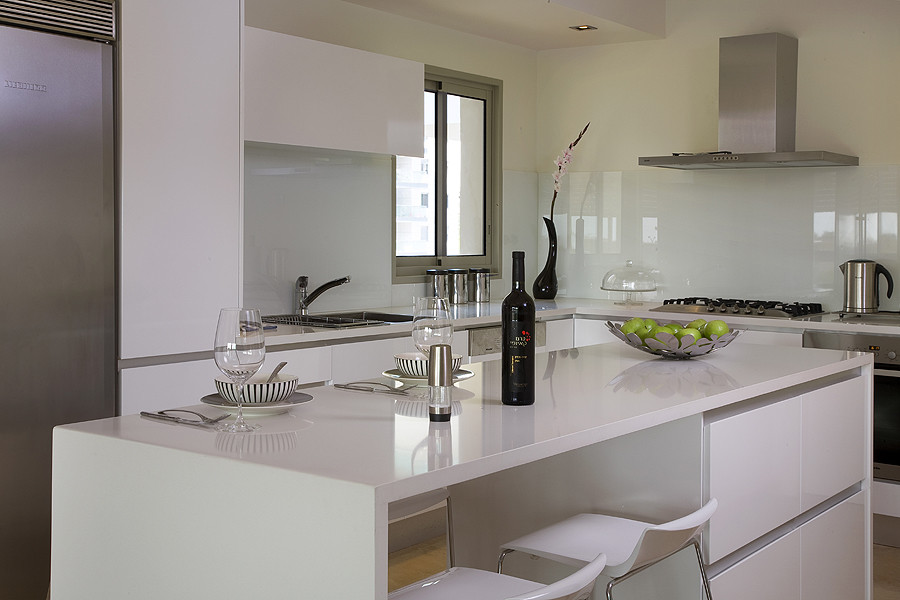 Esempio di una cucina minimalista con paraspruzzi bianco e paraspruzzi con lastra di vetro