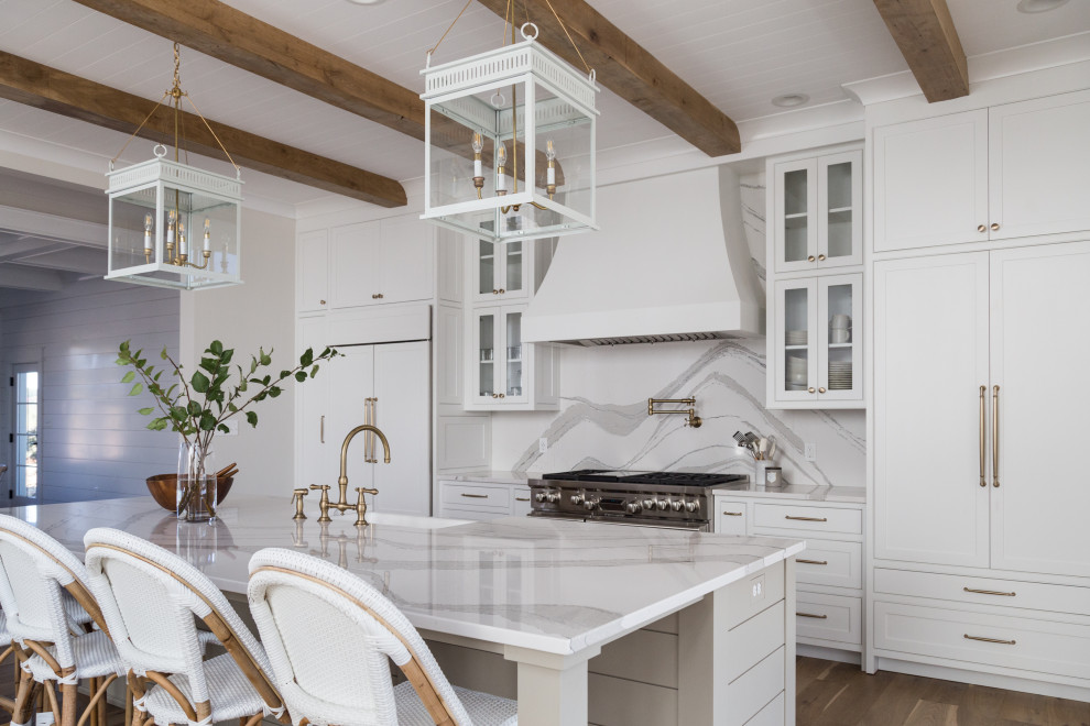 Inspiration for a country galley kitchen in Other with a belfast sink, beaded cabinets, white cabinets, white splashback, stainless steel appliances, medium hardwood flooring, an island, brown floors, white worktops and exposed beams.