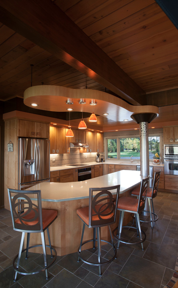 Bild på ett mellanstort funkis kök, med en undermonterad diskho, släta luckor, skåp i mellenmörkt trä, laminatbänkskiva, vitt stänkskydd, stänkskydd i stickkakel, rostfria vitvaror, klinkergolv i keramik och en köksö