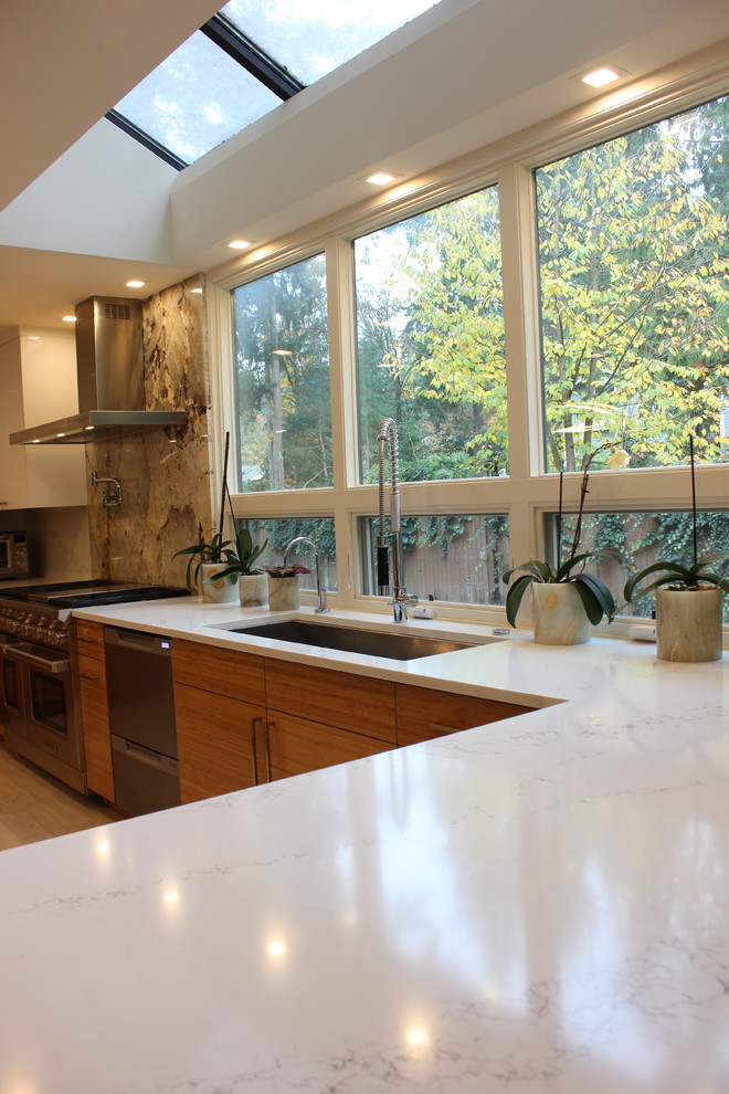 Idéer för ett stort modernt beige kök, med en undermonterad diskho, släta luckor, orange skåp, granitbänkskiva, vitt stänkskydd, rostfria vitvaror, klinkergolv i porslin, en köksö och vitt golv