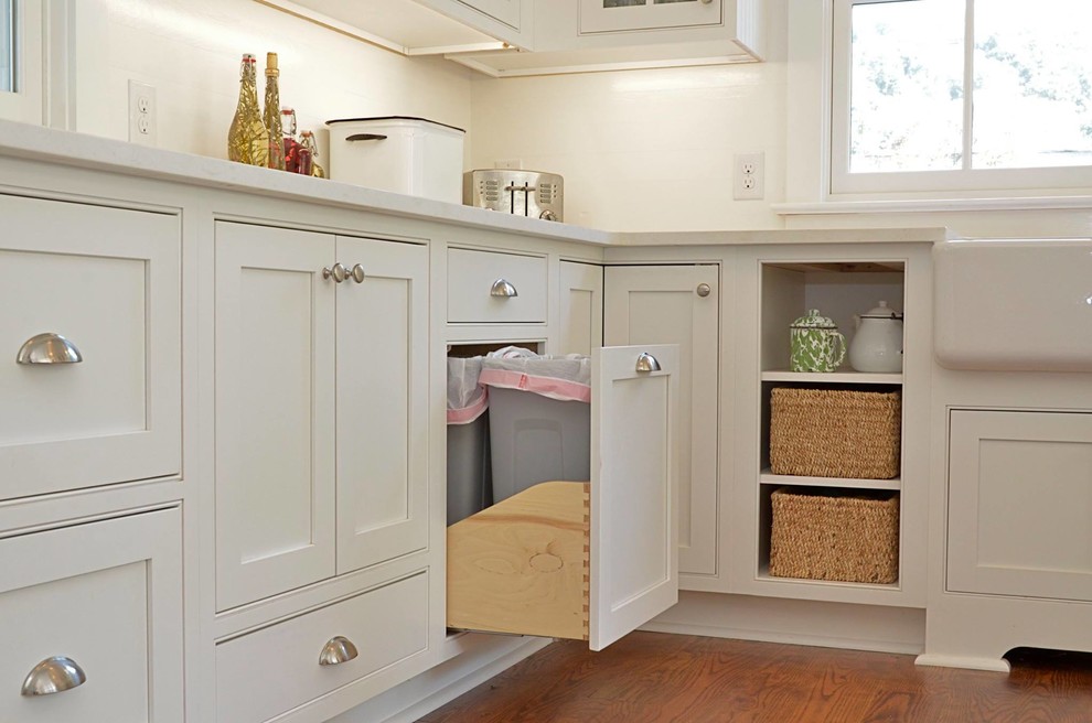 Inspiration for a small farmhouse u-shaped medium tone wood floor eat-in kitchen remodel in Other with a farmhouse sink, beaded inset cabinets, white cabinets, quartz countertops, white backsplash and no island