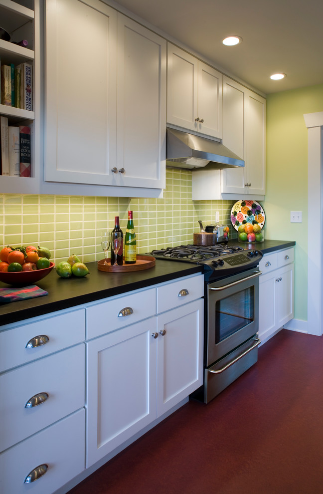 На фото: параллельная кухня в классическом стиле с обеденным столом, врезной мойкой, фасадами в стиле шейкер, белыми фасадами, зеленым фартуком, фартуком из керамической плитки и техникой из нержавеющей стали
