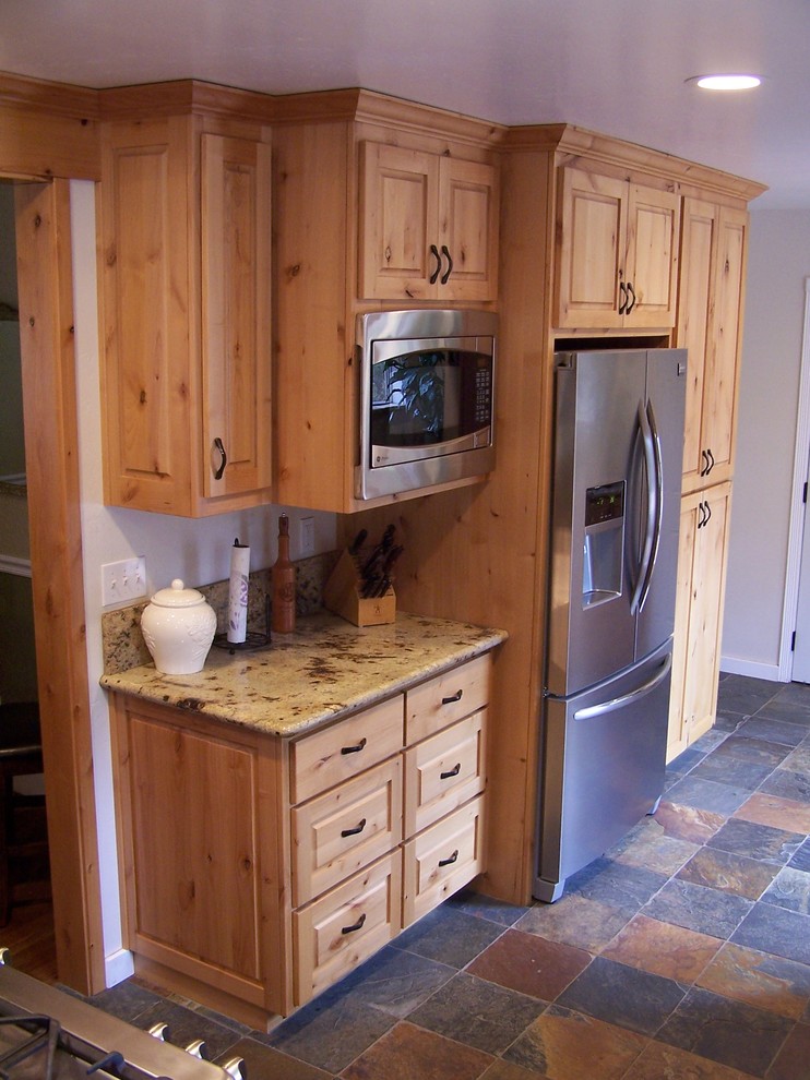 Exempel på ett mellanstort rustikt l-kök, med en undermonterad diskho, luckor med upphöjd panel, skåp i ljust trä, granitbänkskiva, stänkskydd i sten, rostfria vitvaror och skiffergolv