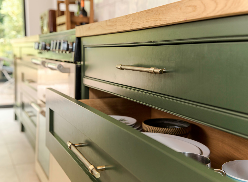 Diseño de cocina comedor clásica grande con armarios estilo shaker, puertas de armario verdes, encimera de madera, una isla y encimeras marrones