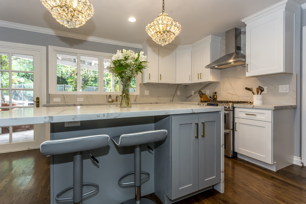 Eat-in kitchen - large transitional u-shaped medium tone wood floor and brown floor eat-in kitchen idea in Los Angeles with an undermount sink, shaker cabinets, white cabinets, marble countertops, red backsplash, marble backsplash, stainless steel appliances and an island