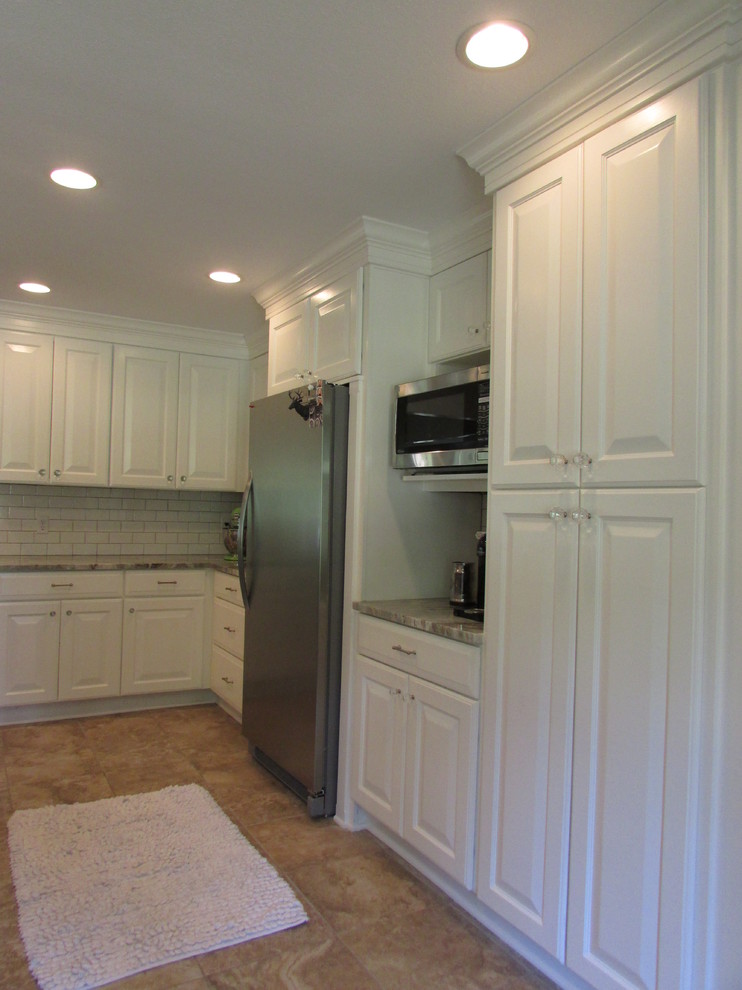 Idéer för att renovera ett funkis kök, med en undermonterad diskho, luckor med upphöjd panel, vita skåp, granitbänkskiva, vitt stänkskydd, stänkskydd i tunnelbanekakel, rostfria vitvaror, klinkergolv i porslin och en köksö