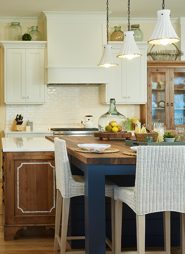 Exempel på ett stort klassiskt kök, med en rustik diskho, luckor med infälld panel, vita skåp, bänkskiva i kvarts, vitt stänkskydd, integrerade vitvaror, mellanmörkt trägolv, en köksö och brunt golv