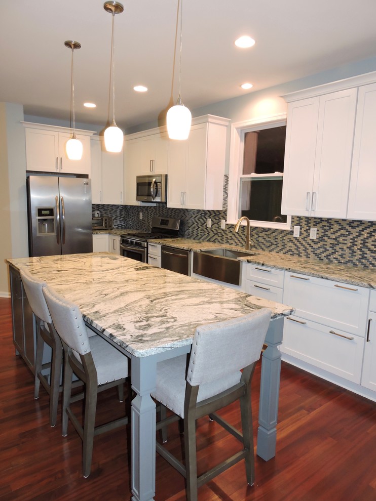 Kitchen - mid-sized contemporary l-shaped dark wood floor and brown floor kitchen idea in Baltimore with a farmhouse sink, shaker cabinets, white cabinets, granite countertops, multicolored backsplash, mosaic tile backsplash, stainless steel appliances and an island