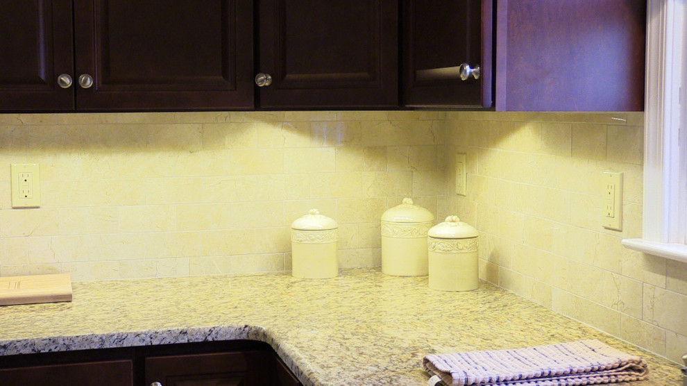 Exempel på ett avskilt, litet u-kök, med en enkel diskho, luckor med upphöjd panel, skåp i mörkt trä, granitbänkskiva, beige stänkskydd, stänkskydd i porslinskakel, rostfria vitvaror och klinkergolv i porslin
