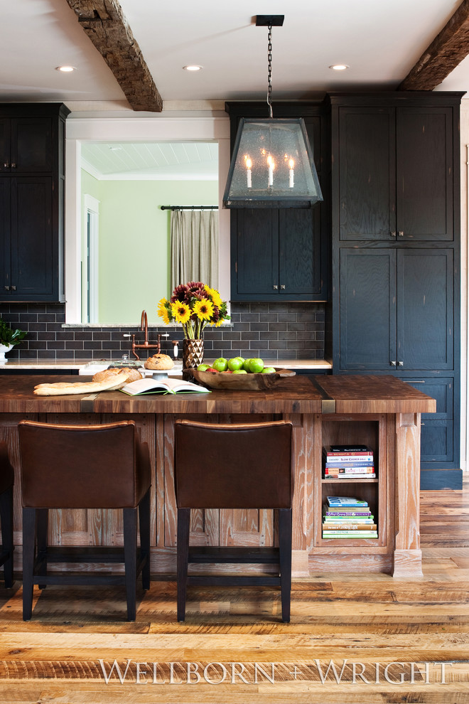 Immagine di una cucina eclettica con lavello sottopiano, ante con riquadro incassato, ante nere, top in legno e paraspruzzi grigio