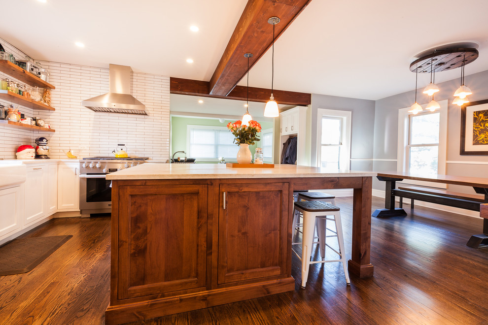 Eat-in kitchen - large cottage u-shaped medium tone wood floor and brown floor eat-in kitchen idea in Chicago with a farmhouse sink, beaded inset cabinets, white cabinets, quartzite countertops, white backsplash, subway tile backsplash, stainless steel appliances and an island