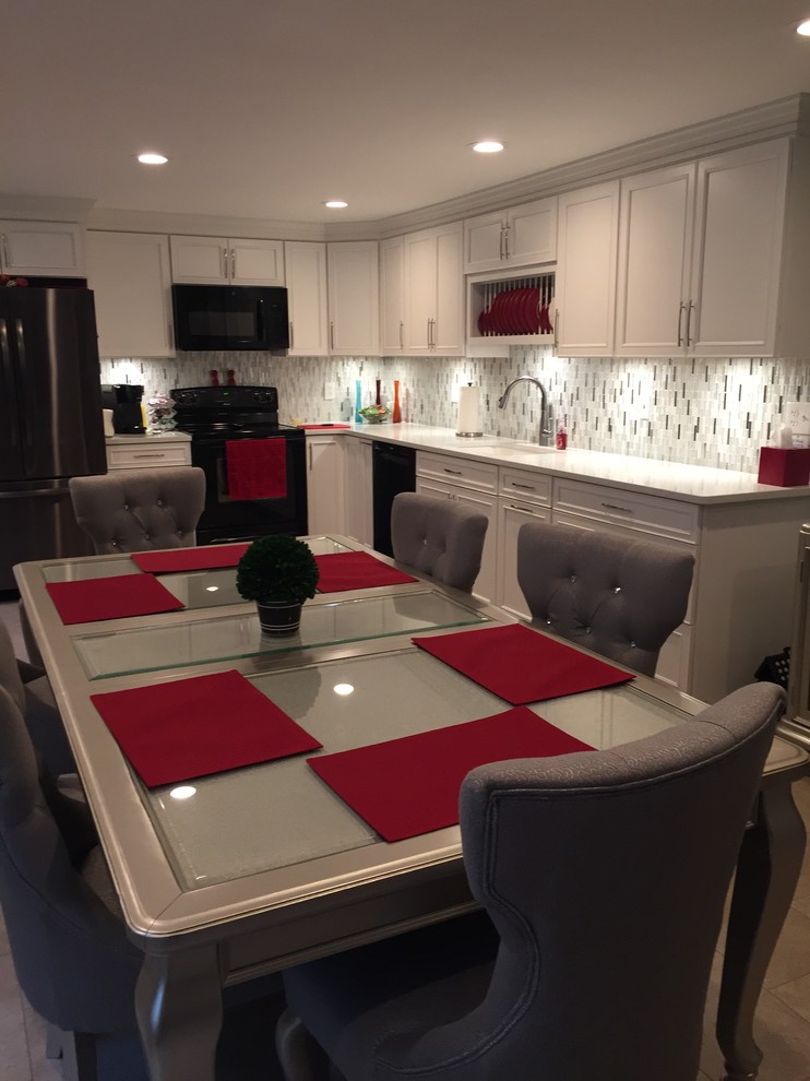 Example of a mid-sized trendy l-shaped vinyl floor and beige floor eat-in kitchen design in New York with an undermount sink, recessed-panel cabinets, white cabinets, quartz countertops, white backsplash, mosaic tile backsplash, black appliances, no island and white countertops