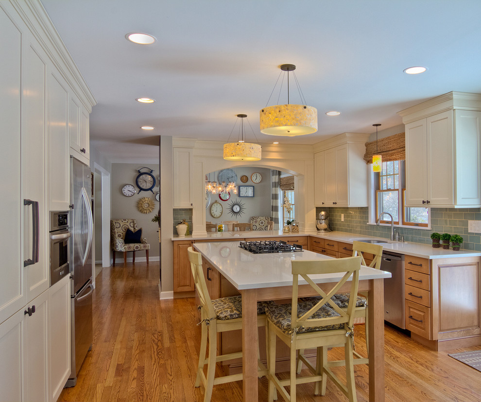 Mid-sized transitional l-shaped medium tone wood floor eat-in kitchen photo in Detroit with an undermount sink, recessed-panel cabinets, light wood cabinets, solid surface countertops, blue backsplash, glass tile backsplash, stainless steel appliances and an island
