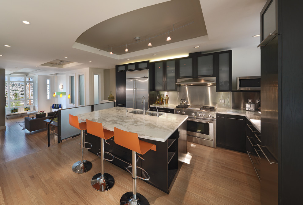 Trendy kitchen photo in San Francisco with glass-front cabinets, stainless steel appliances and marble countertops