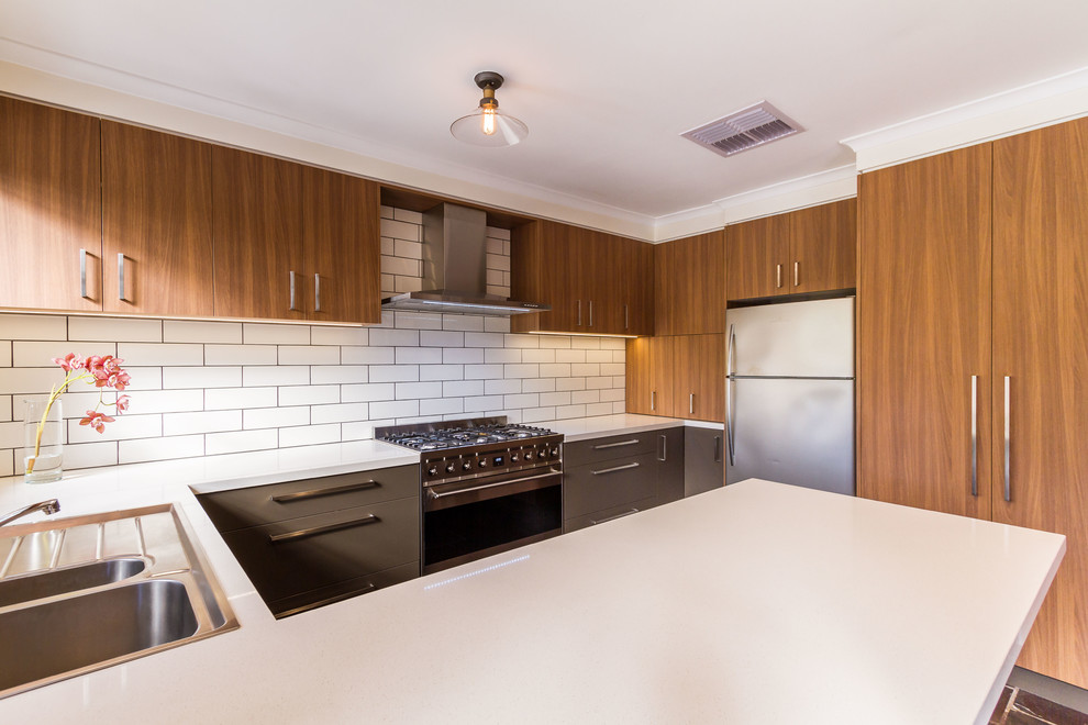 Design ideas for a medium sized retro u-shaped kitchen/diner in Melbourne with a built-in sink, flat-panel cabinets, grey cabinets, engineered stone countertops, white splashback, ceramic splashback, stainless steel appliances, slate flooring, a breakfast bar, grey floors and white worktops.