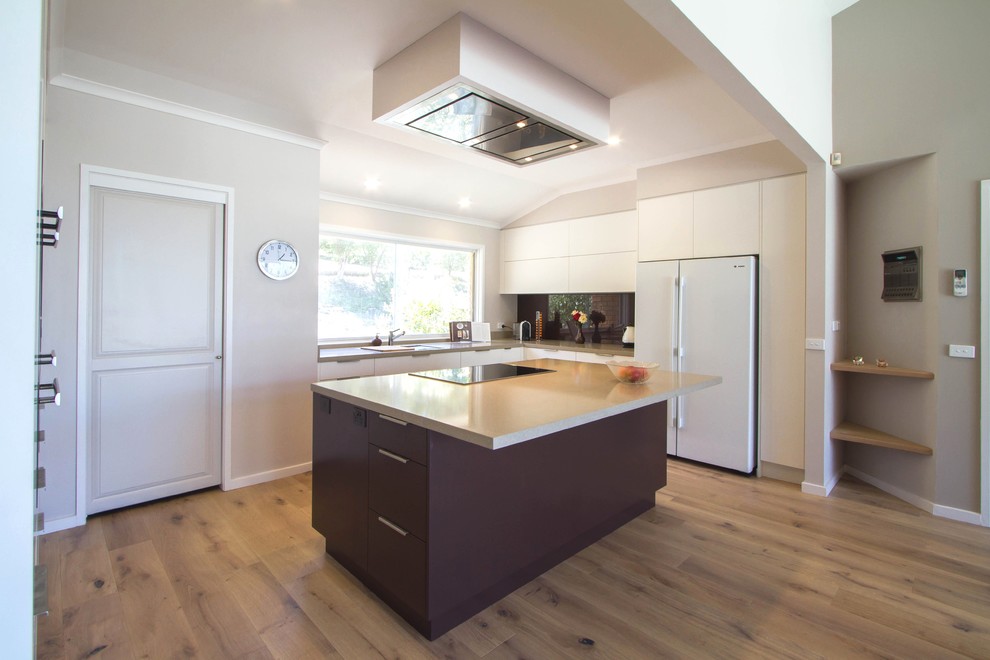 Esempio di una grande cucina minimalista con ante lisce, top in quarzo composito e paraspruzzi con piastrelle di vetro