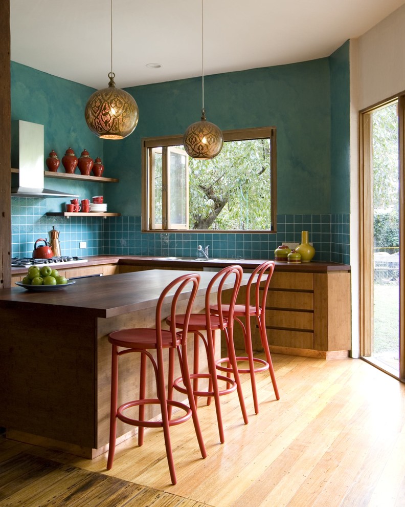 Large transitional u-shaped light wood floor eat-in kitchen photo in Melbourne with flat-panel cabinets, medium tone wood cabinets, blue backsplash, an undermount sink, wood countertops, ceramic backsplash, stainless steel appliances and an island