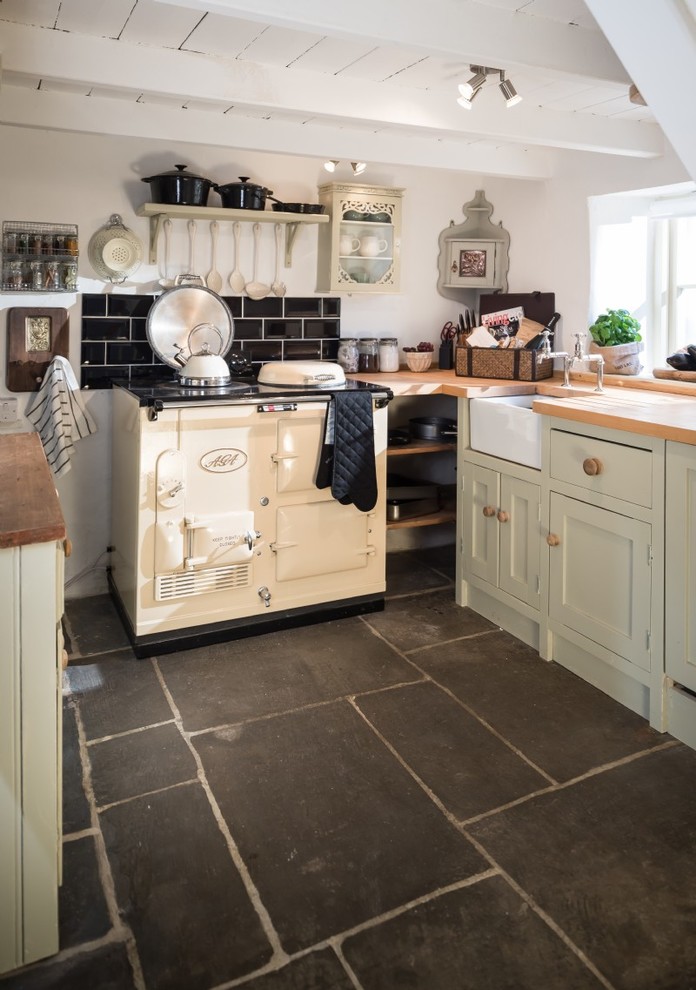 Esempio di una cucina abitabile country con lavello stile country, ante beige, top in legno e pavimento in ardesia