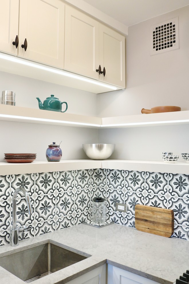 Photo of a small classic l-shaped kitchen in Chicago with a submerged sink, shaker cabinets, white cabinets, engineered stone countertops, grey splashback, cement tile splashback, stainless steel appliances, medium hardwood flooring, no island and brown floors.