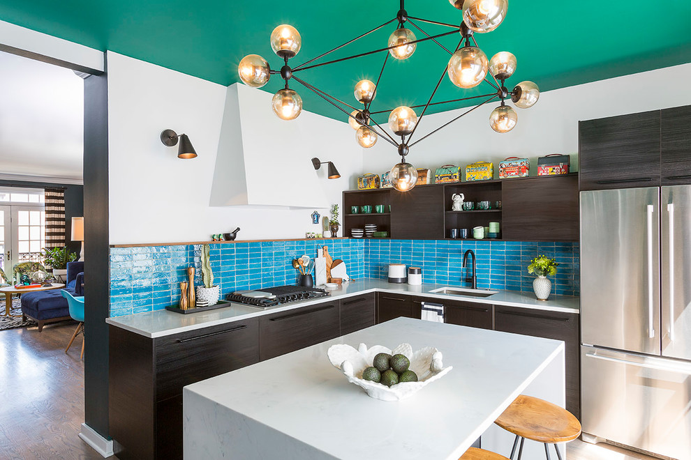 Foto på ett avskilt, mellanstort eklektiskt l-kök, med en undermonterad diskho, släta luckor, skåp i mörkt trä, bänkskiva i kvarts, blått stänkskydd, stänkskydd i terrakottakakel, rostfria vitvaror och en köksö