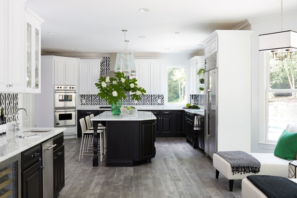 Design ideas for a classic l-shaped kitchen/diner in DC Metro with a submerged sink, raised-panel cabinets, black cabinets, multi-coloured splashback, stainless steel appliances, medium hardwood flooring, an island, grey floors and white worktops.