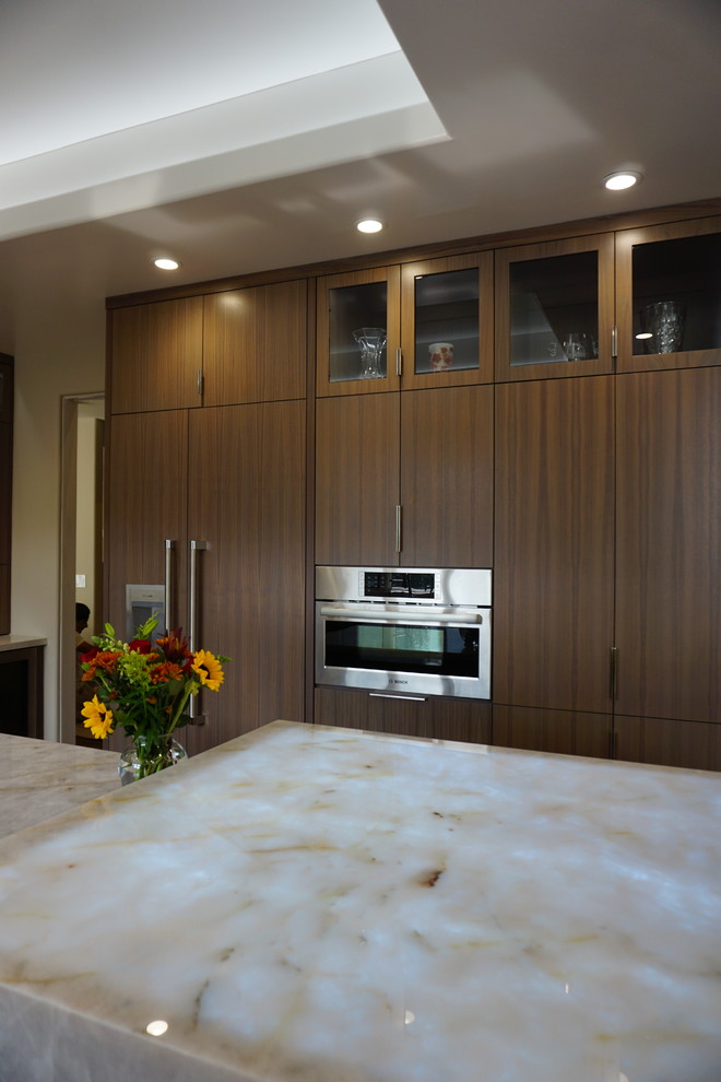 Example of a large trendy u-shaped medium tone wood floor and brown floor open concept kitchen design in San Francisco with an undermount sink, flat-panel cabinets, medium tone wood cabinets, quartzite countertops, white backsplash, stone slab backsplash, paneled appliances, an island and white countertops