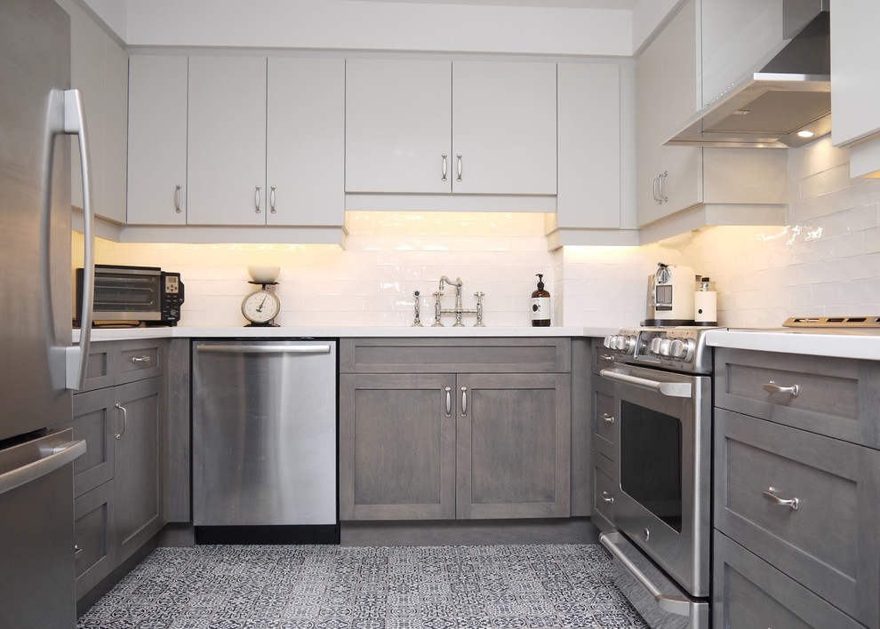 Photo of a small modern u-shaped enclosed kitchen in Toronto with a submerged sink, engineered stone countertops, white splashback, porcelain splashback, stainless steel appliances and porcelain flooring.