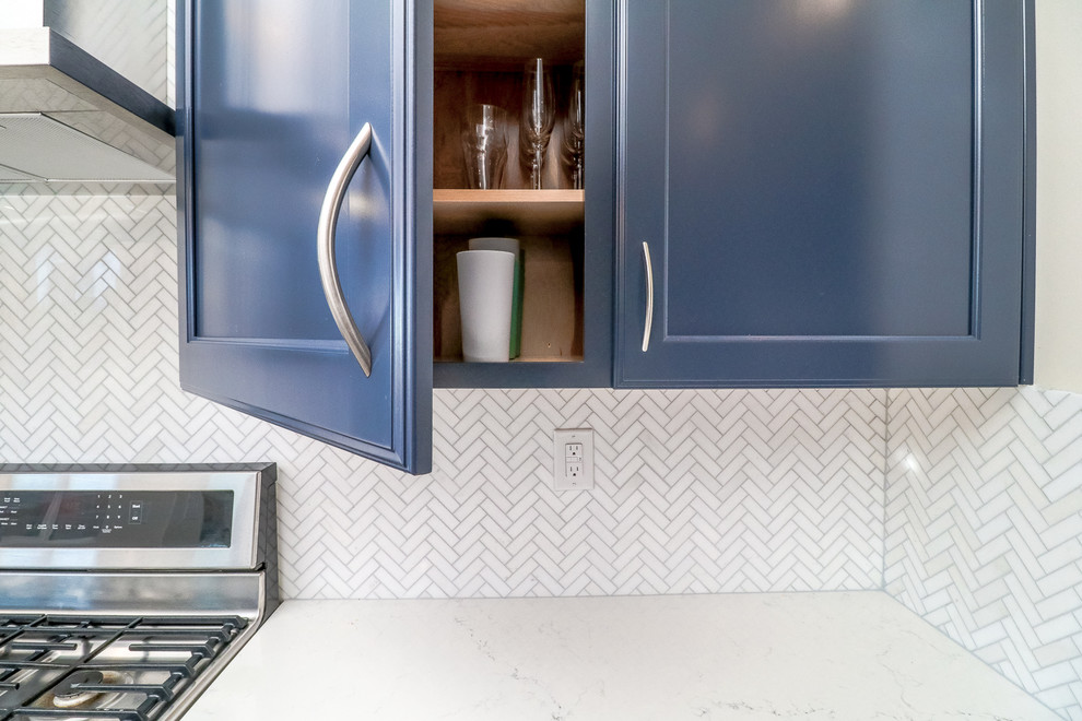 Idéer för ett mellanstort modernt vit kök, med en undermonterad diskho, luckor med infälld panel, blå skåp, bänkskiva i kvarts, vitt stänkskydd, rostfria vitvaror, klinkergolv i porslin, en köksö, brunt golv och stänkskydd i marmor
