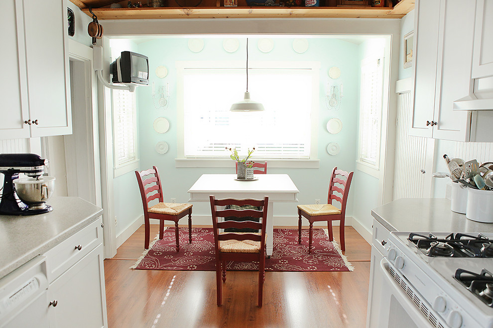 Eat-in kitchen - traditional u-shaped eat-in kitchen idea in Columbus with shaker cabinets, white cabinets and white appliances