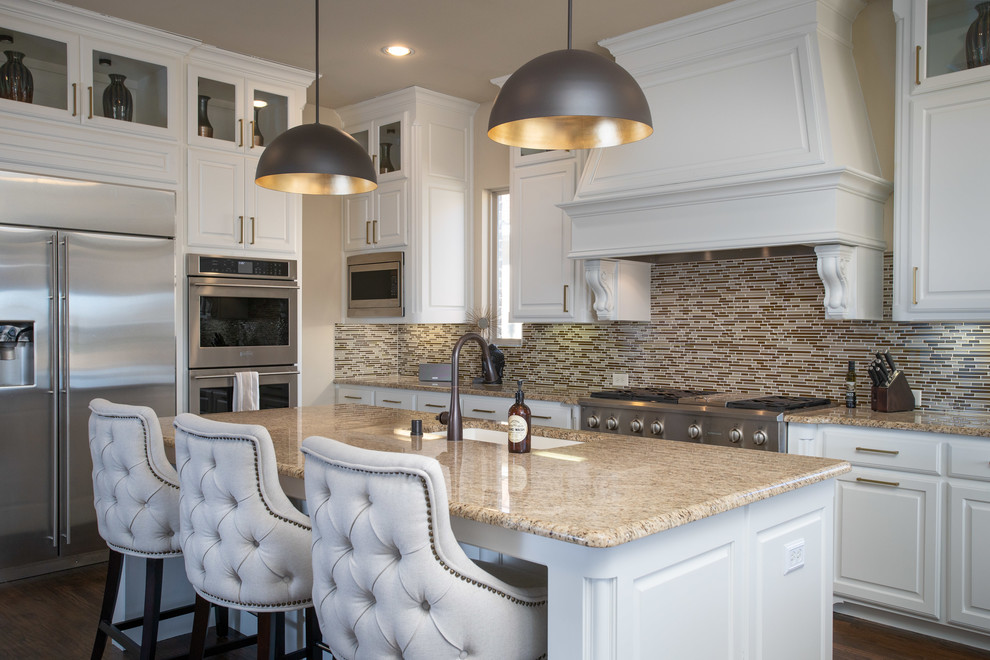 Bild på ett medelhavsstil beige beige kök, med en undermonterad diskho, luckor med upphöjd panel, vita skåp, flerfärgad stänkskydd, stänkskydd i stickkakel, rostfria vitvaror, mörkt trägolv, en köksö och brunt golv