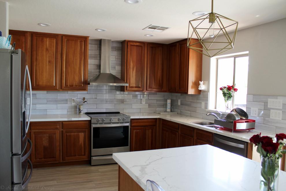 Exempel på ett mellanstort modernt vit vitt kök, med en undermonterad diskho, bänkskiva i kvarts, grått stänkskydd, stänkskydd i keramik, rostfria vitvaror, klinkergolv i porslin, en köksö och brunt golv