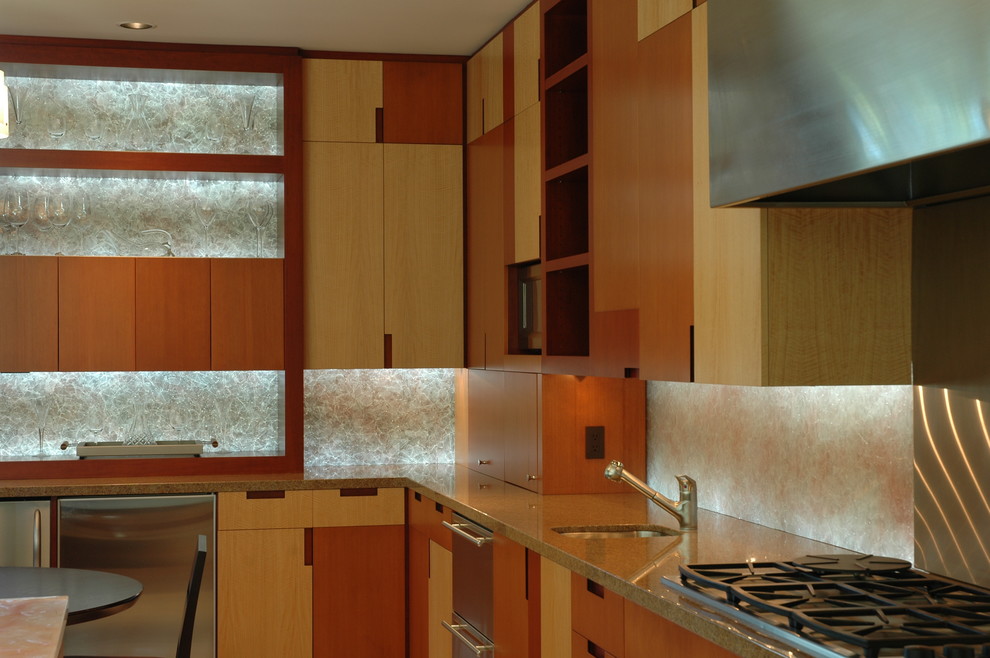 Idéer för funkis kök, med en undermonterad diskho, släta luckor, bänkskiva i glas, glaspanel som stänkskydd, rostfria vitvaror, kalkstensgolv och en köksö