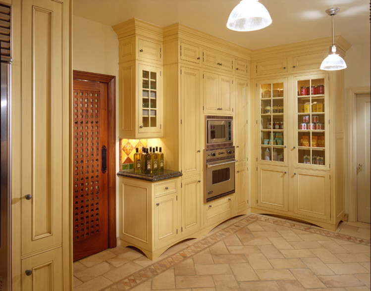 Example of a large tuscan travertine floor kitchen pantry design in Miami with raised-panel cabinets, yellow cabinets, granite countertops, multicolored backsplash, ceramic backsplash and stainless steel appliances