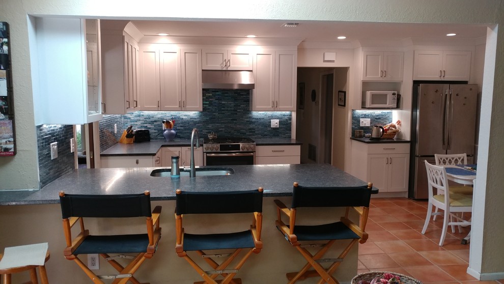 Mid-sized transitional u-shaped terra-cotta tile and orange floor eat-in kitchen photo in Tampa with an undermount sink, shaker cabinets, white cabinets, granite countertops, blue backsplash, mosaic tile backsplash, stainless steel appliances, a peninsula and gray countertops