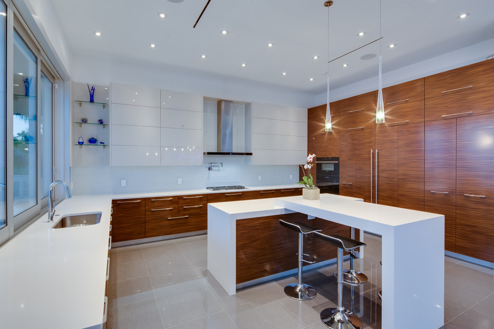 На фото: угловая кухня в современном стиле с врезной мойкой, плоскими фасадами, фасадами цвета дерева среднего тона и белым фартуком