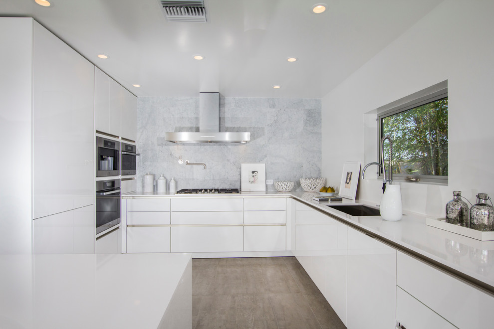 Mid-sized trendy u-shaped porcelain tile open concept kitchen photo in San Diego with a single-bowl sink, flat-panel cabinets, white cabinets, quartz countertops, stainless steel appliances and an island