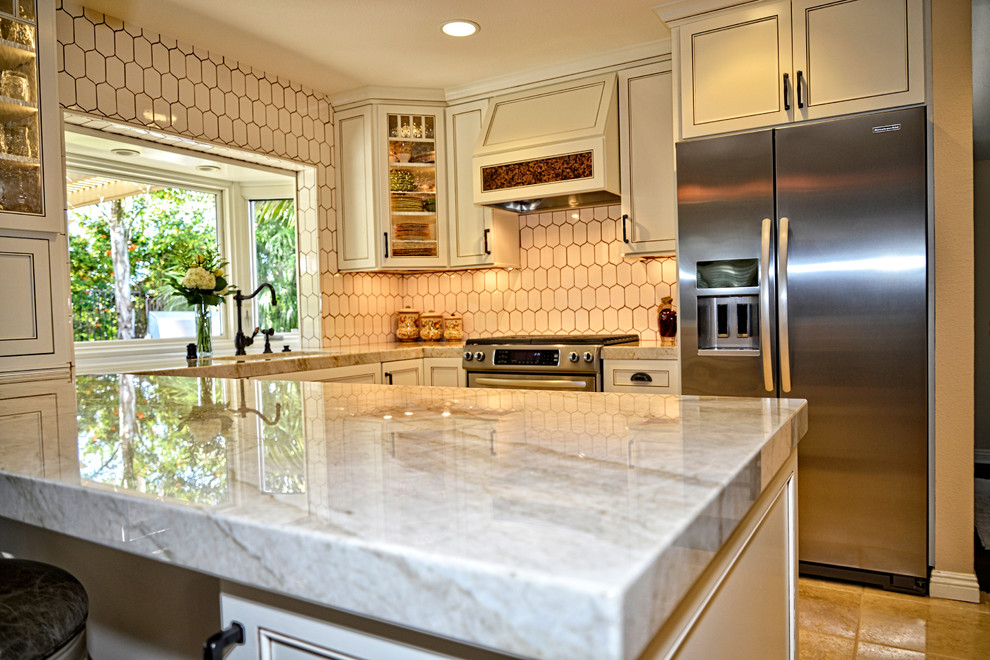 Eat-in kitchen - mid-sized cottage u-shaped travertine floor and beige floor eat-in kitchen idea in San Diego with white cabinets, white backsplash, stainless steel appliances, a peninsula, an undermount sink, recessed-panel cabinets, marble countertops and porcelain backsplash