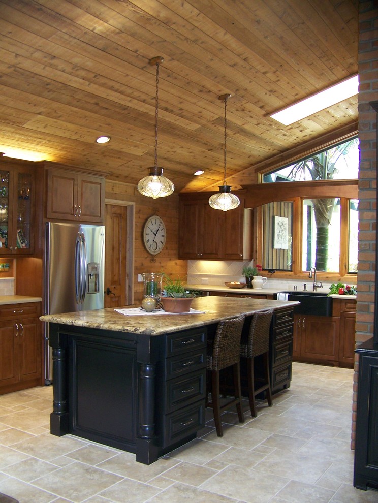 Inredning av ett klassiskt mellanstort kök, med rostfria vitvaror, en rustik diskho, luckor med upphöjd panel, skåp i mellenmörkt trä, bänkskiva i kvarts, beige stänkskydd, stänkskydd i keramik, klinkergolv i keramik, en köksö och beiget golv