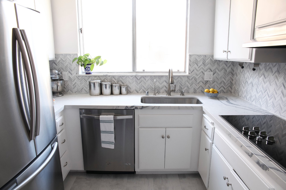 Example of a small trendy u-shaped porcelain tile and gray floor eat-in kitchen design in Los Angeles with an undermount sink, flat-panel cabinets, white cabinets, quartz countertops, gray backsplash, porcelain backsplash, stainless steel appliances and no island