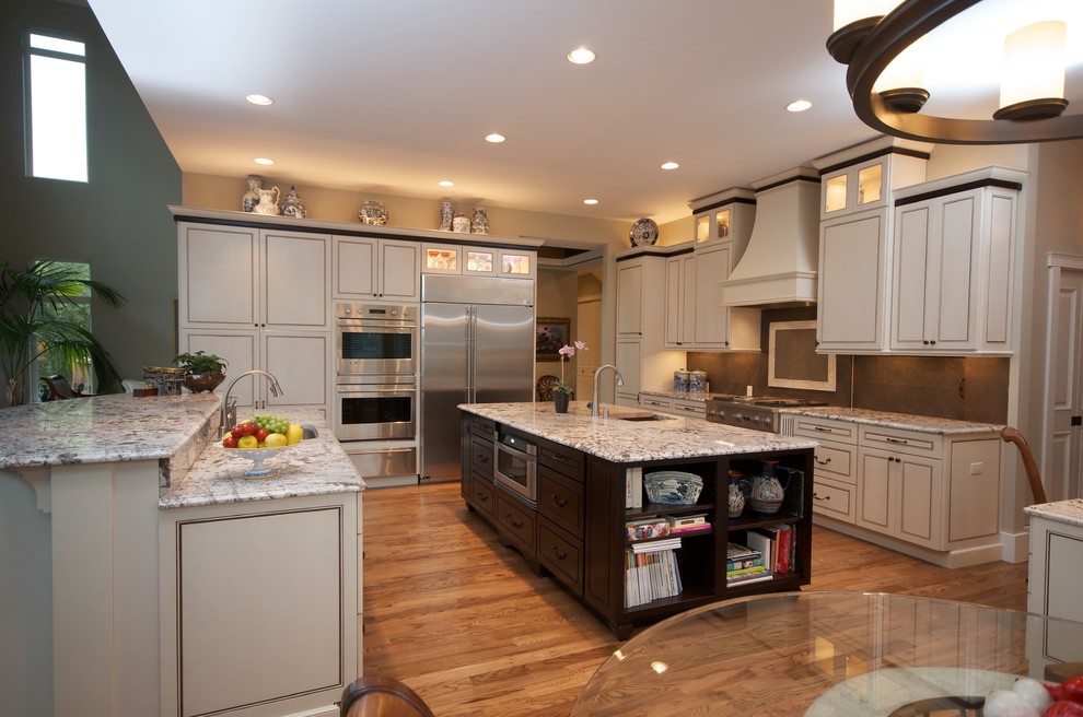 Example of a large classic light wood floor kitchen pantry design in Other with granite countertops and stainless steel appliances