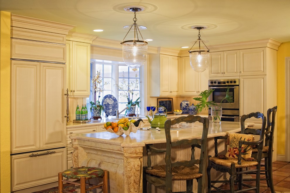マイアミにあるトラディショナルスタイルのおしゃれなII型キッチン (レイズドパネル扉のキャビネット、ベージュのキャビネット、パネルと同色の調理設備) の写真