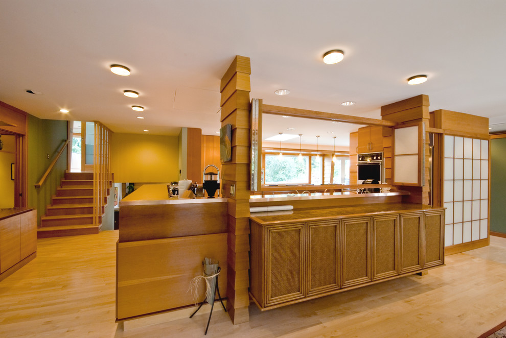 Inspiration for a mid-sized transitional l-shaped light wood floor open concept kitchen remodel in Portland with a peninsula, flat-panel cabinets, medium tone wood cabinets, copper countertops, black backsplash, stone slab backsplash, stainless steel appliances and a double-bowl sink