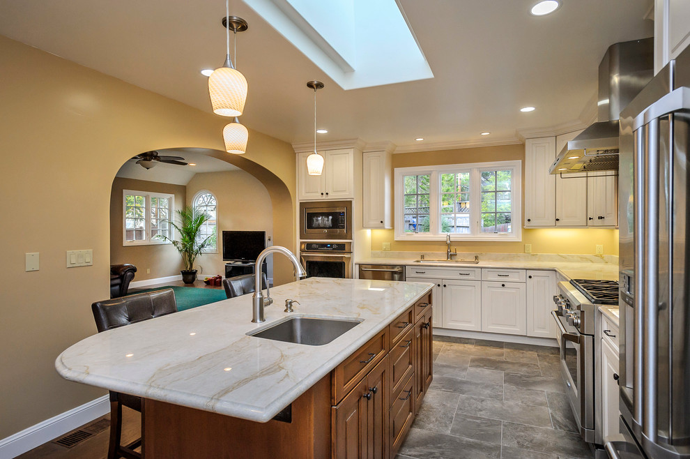 Elegant l-shaped open concept kitchen photo in Other with an undermount sink, raised-panel cabinets, white cabinets, granite countertops, beige backsplash and stainless steel appliances