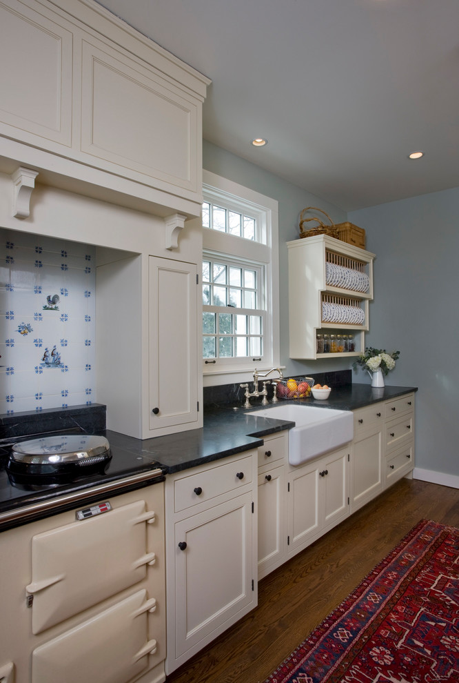 Small traditional galley enclosed kitchen in Chicago with a belfast sink, beaded cabinets, white cabinets, soapstone worktops, coloured appliances, medium hardwood flooring, no island and black worktops.