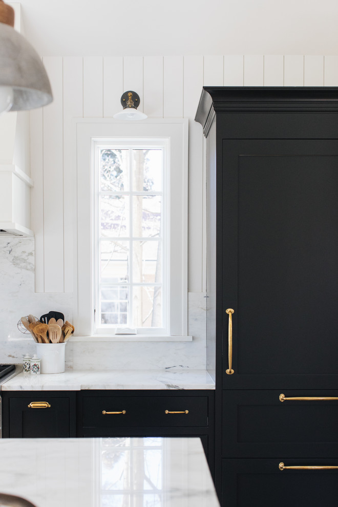 Inredning av ett klassiskt mellanstort l-kök, med en rustik diskho, skåp i shakerstil, svarta skåp, marmorbänkskiva, vitt stänkskydd, stänkskydd i marmor, integrerade vitvaror, mellanmörkt trägolv, en köksö och brunt golv