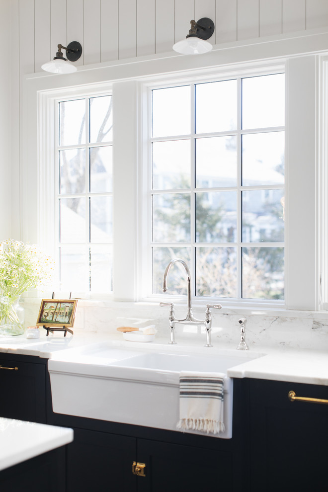 Foto på ett mellanstort vintage l-kök, med en rustik diskho, skåp i shakerstil, svarta skåp, marmorbänkskiva, vitt stänkskydd, stänkskydd i marmor, integrerade vitvaror, mellanmörkt trägolv, en köksö och brunt golv