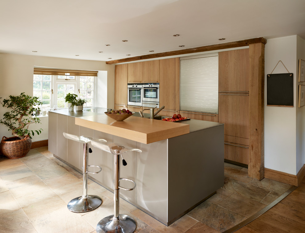Imagen de cocina contemporánea con armarios con paneles lisos, puertas de armario de madera oscura, electrodomésticos de acero inoxidable y una isla